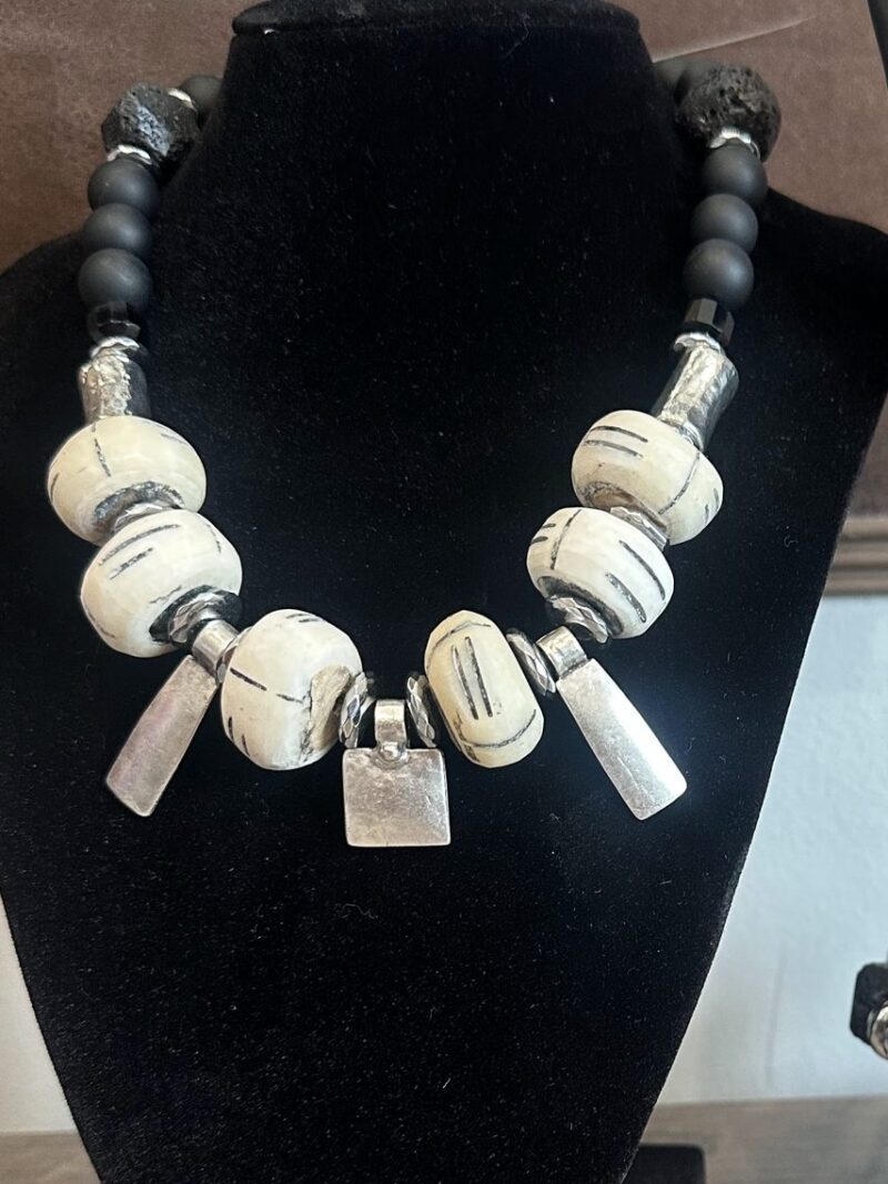 Style N08 – Matte black onyx, black lava stone, carved cream bone rondelles, hammered silver tubes and three silver tag drops